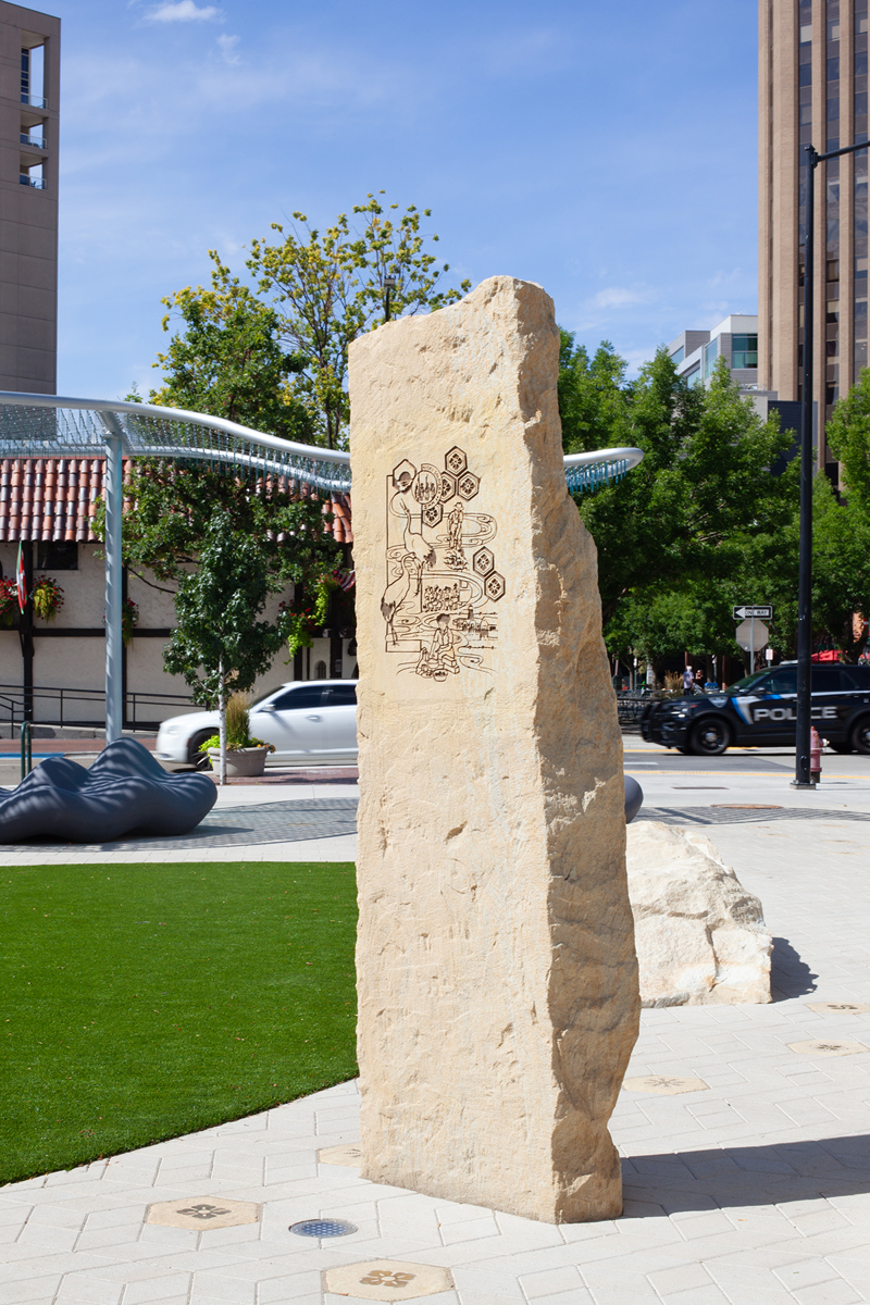 A sandstone pillar with an etching of Japanese motifs and symbols.