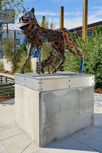 Coyote and her pup crafted from found metals displayed on a raised platform.