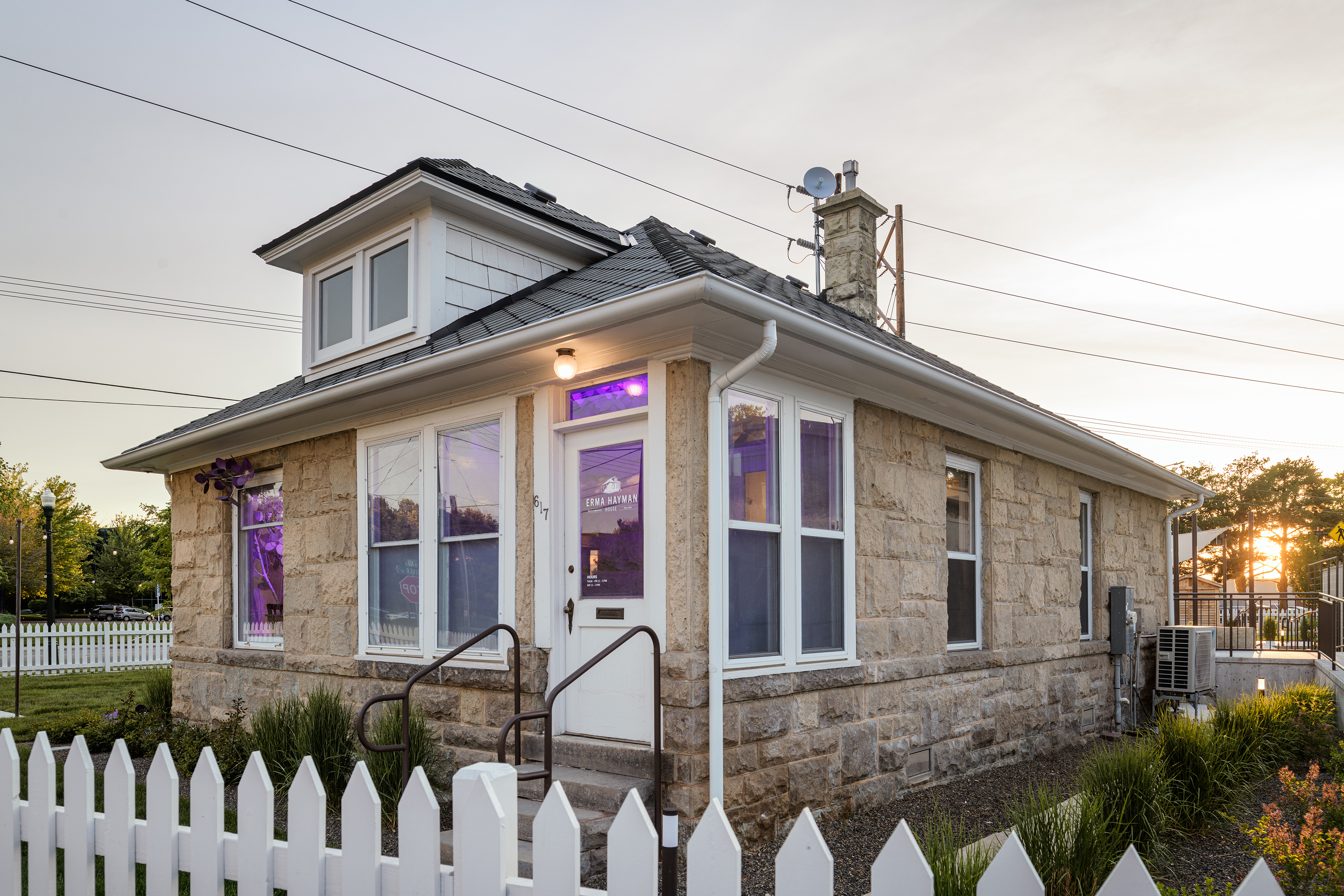 Exterior of Erma Hayman House with windows glowing with purple light from inside.