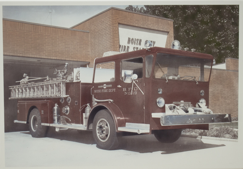 An image of a red firetruck at a fire station in 1975.