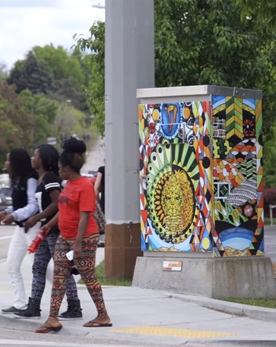 People walking past traffic box art