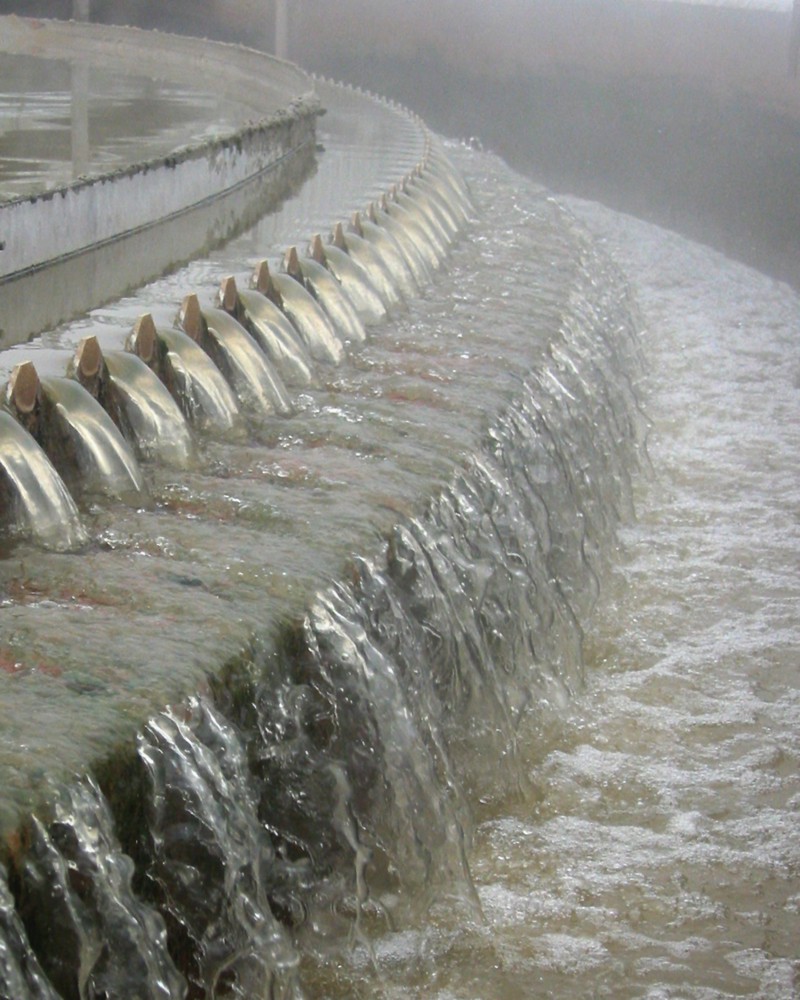 Water cascading down several tiers of a separator meant to remove unwanted materials. The water appears to be steaming as though heated.