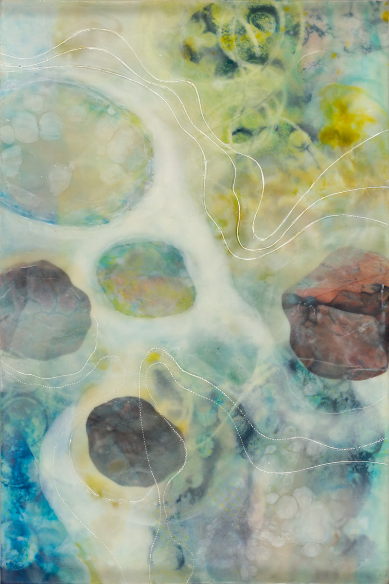 A mixed media artwork using encaustic wax and printed images to give the impression of stones in a river. 