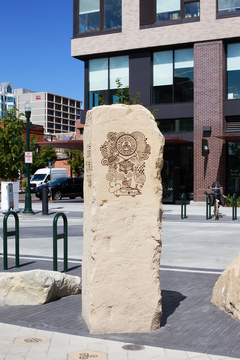A sandstone pillar with an etching of Irish motifs and symbols.