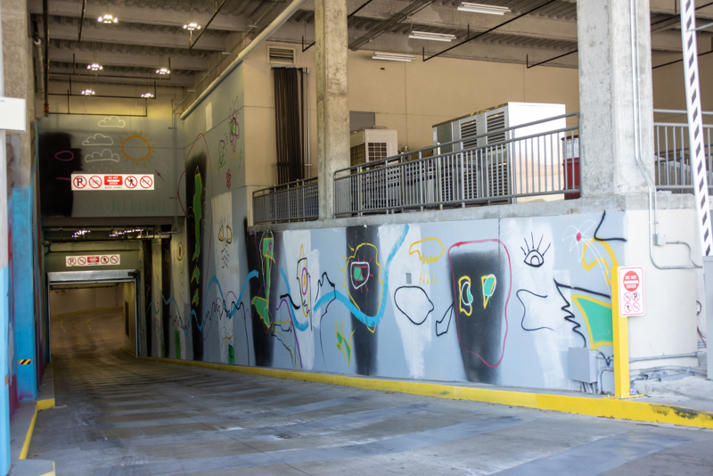 An abstract spray paint mural on both sides of the Boise VRT Main St. Station bus tunnel.