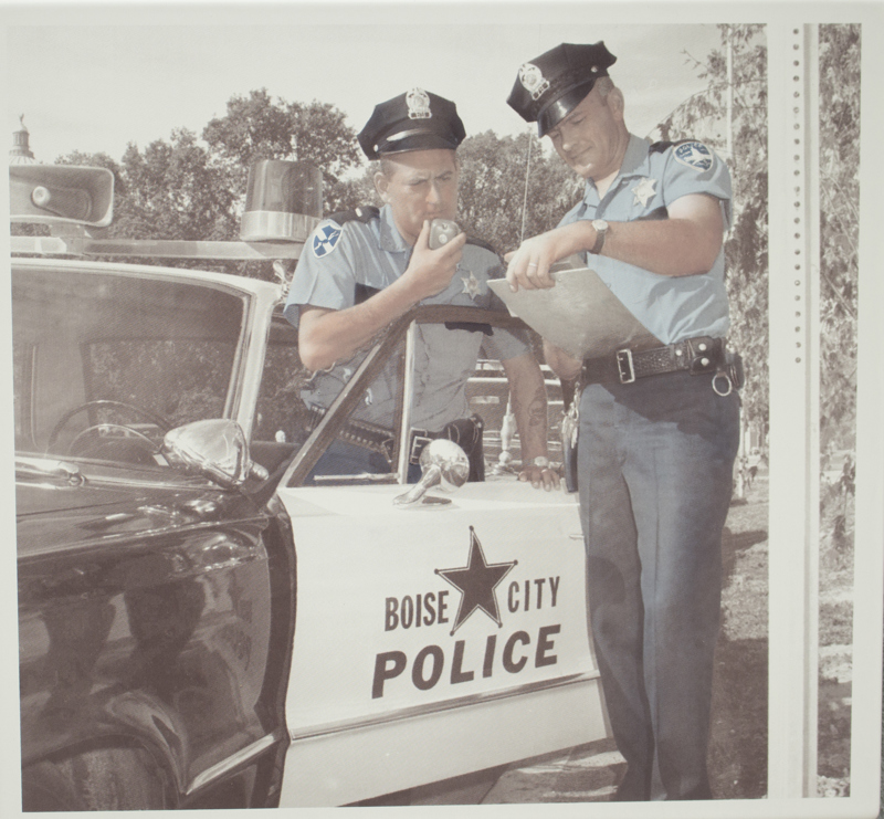 An image of two police officers standing next to a Boise Police car.