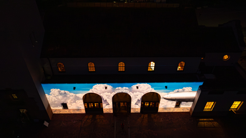 An ariel photograph of the Boise Depot at sunset. On the front of the building is a bright animated projection.