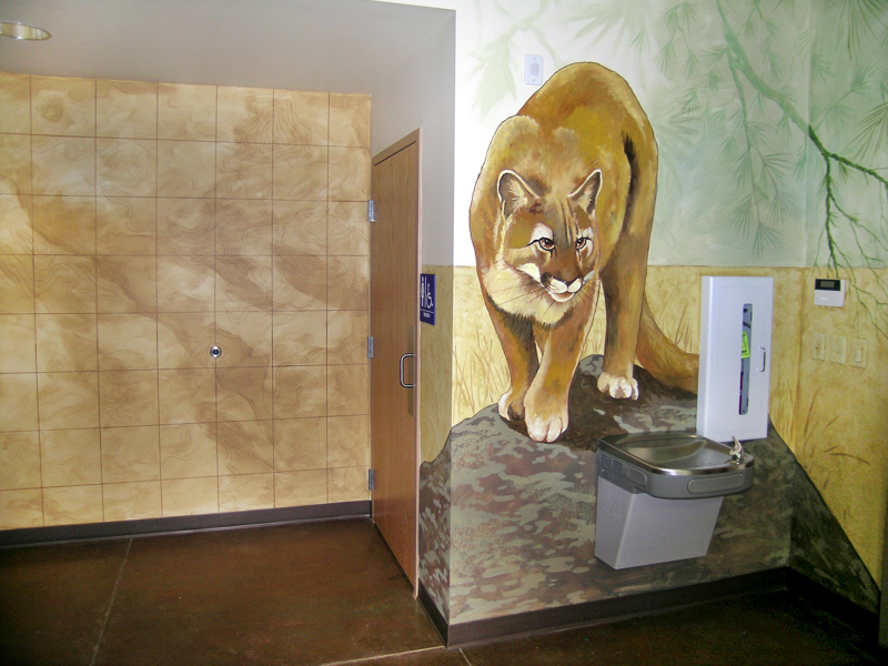 The main office of the Boise Foothills Learning Center. On the walls painted over a drinking fountain is a mountain lion standing on a rock.