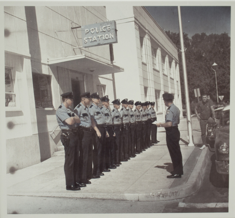 An image of a line of police officers standing in front of the old Boise City Hall Annex in 1966.