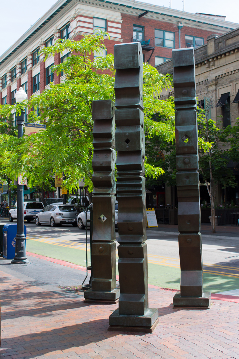 Three bronze sculptures of geometrically abstracted columns. 