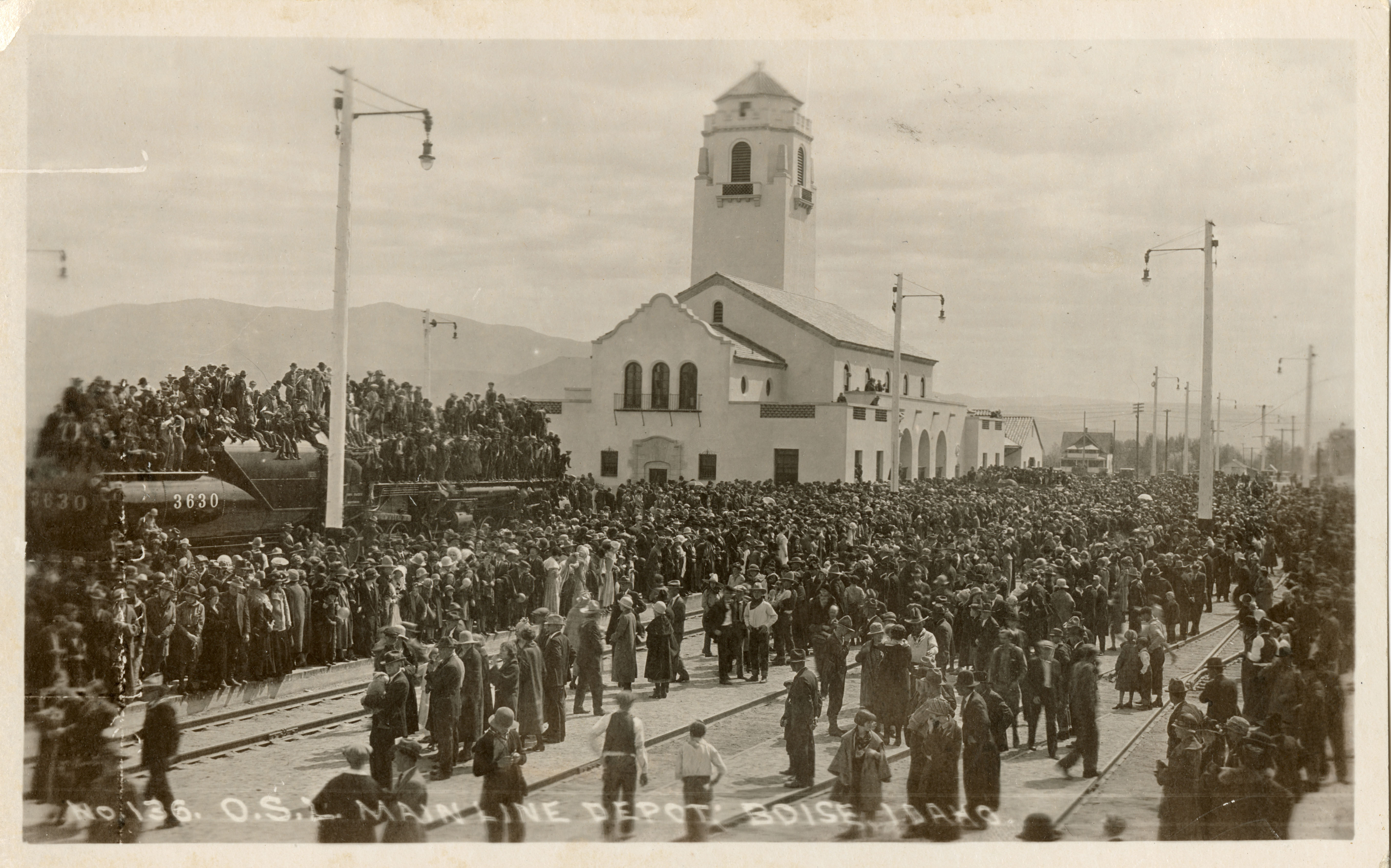Historic image of the Boise Depot with hundreds of people surrounding the building and on the tracks.