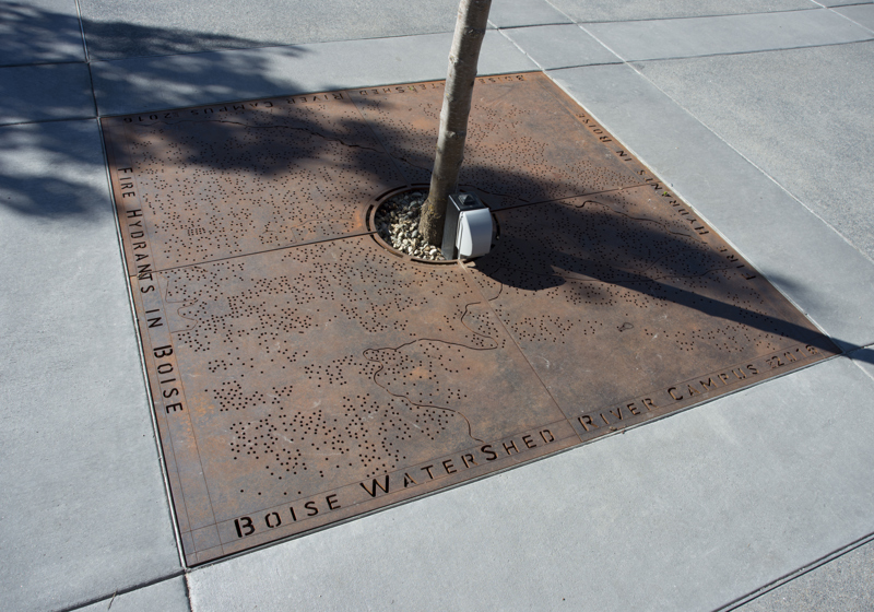 A steel tree grate cut to depict a map locating all the fire hydrants in Boise.