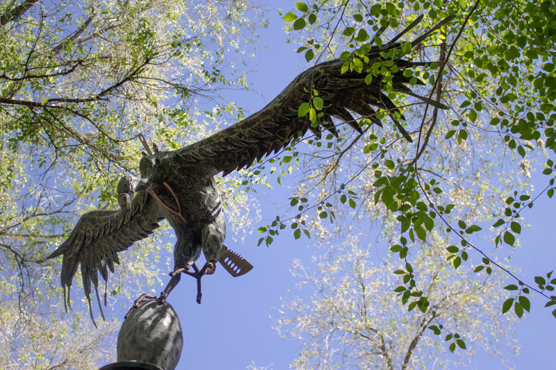 A sculpture of a flying vulture made of found metal materials. On its breast is a wish bone. 